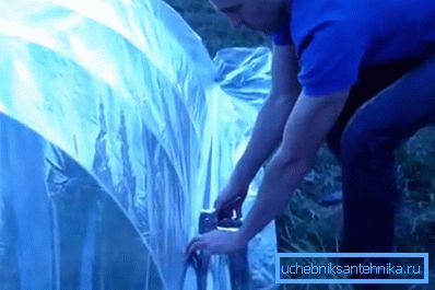 Installation de film de cellophane sur le squelette de la serre Installation de film de cellophane sur le squelette de la serre