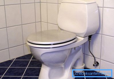 Installation d'une cuvette de toilettes d'un système compact sur un sol en carreaux de céramique.
