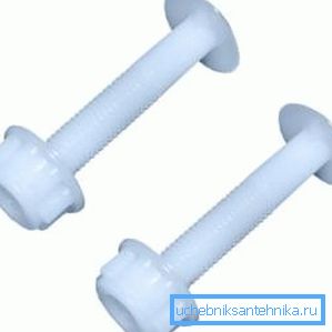 Dans les vis en plastique photo et un écrou pour fixer le siège de toilette à la toilette.