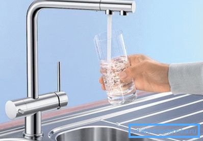 La photo montre un robinet de cuisine avec un robinet d'eau potable. La photo montre un robinet de cuisine avec un robinet d'eau potable.