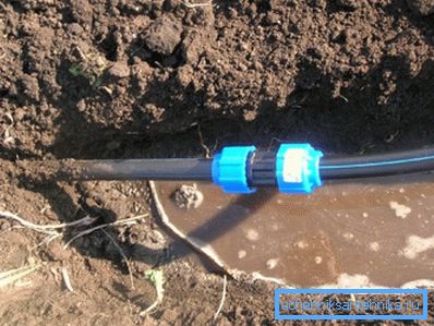 Sur la photo, le système d'alimentation en eau en polyéthylène est posé dans un sol humide. Sur la photo, le système d'alimentation en eau en polyéthylène est posé dans un sol humide.