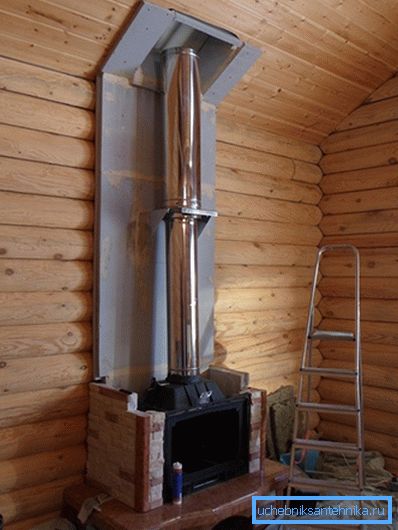 La photo montre un exemple d'installation d'un tuyau en acier dans un chalet en bois.