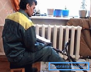 Sur la photo, le plombier lave les radiateurs de l'appartement Sur la photo, le plombier lave les radiateurs de l'appartement