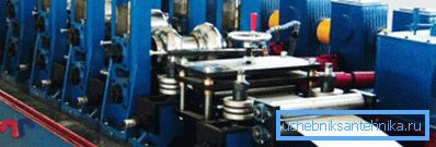 Sur la photo dans la machine est alimenté une bande en acier pour la production de tuyaux Sur la photo dans la machine est alimenté une bande en acier pour la production de tuyaux