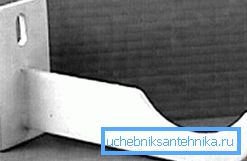 Au premier abord, les petits crochets pour les produits en fonte sont fixés au mur à l'aide d'ancrages en acier Au premier abord, les petits crochets pour les produits en fonte sont fixés au mur à l'aide d'ancrages en acier