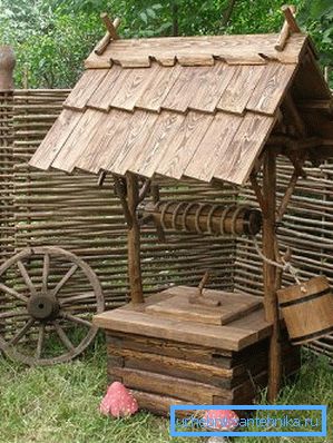 Ce puits ressemble harmonieusement à une pelouse verte en combinaison avec une clôture en bois ou en osier Ce puits ressemble harmonieusement à une pelouse verte en combinaison avec une clôture en bois ou en osier