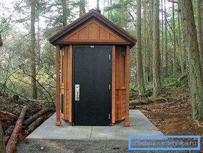 Toilette isolée sur un socle en béton avec une porte en métal